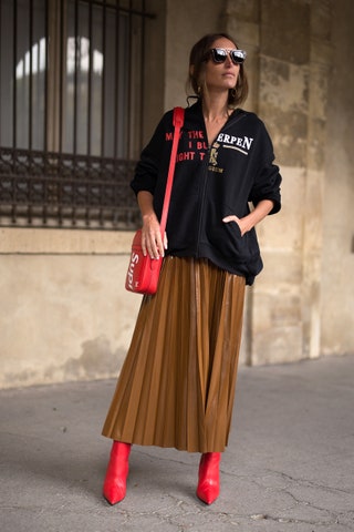 Лу Лу Десаисом в толстовке Vetements юбке Balenciaga ботильонах Cline и с сумкой Supreme x LV на Неделе моды в Париже.
