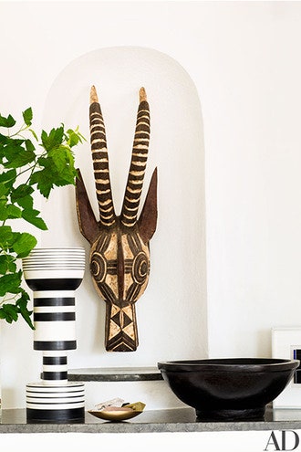 Африканская маска в нише рифмуется с вазой итальянского архитектора Этторе Соттсасса для Bitossi