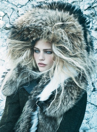 В шерстяном пальто накидке из меха лисы и меха енота и шапке из меха лисы Fendi.
