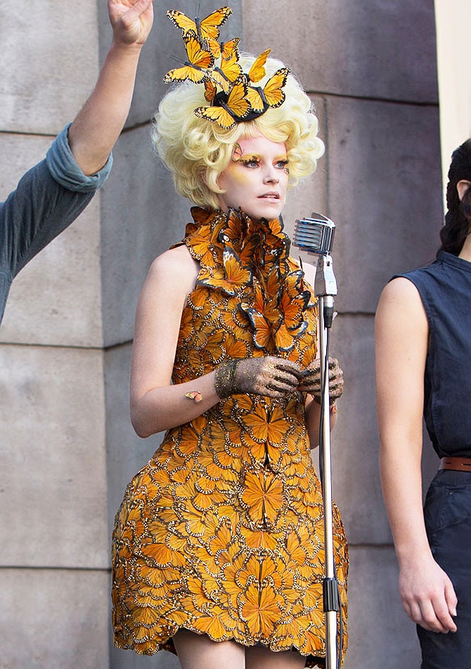 Эффи Тринкет в Alexander McQueen  костюмеры фильма украсили бабочками руки лицо и даже ресницы героини «Голодных игр»