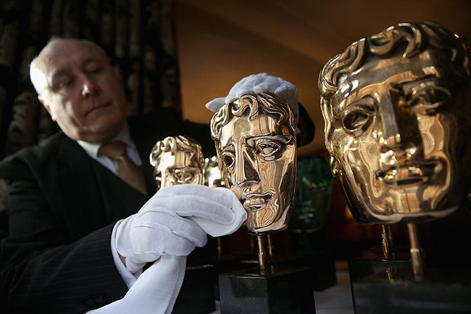 Отполированные до блеска призы Британской академии кино и телевизионных искусств выполненные в виде актерских масок