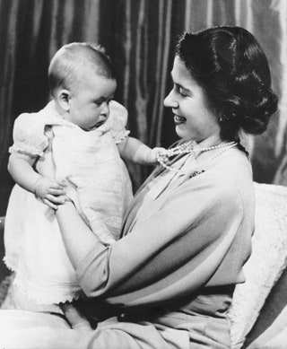Елизавета II с маленьким принцем Чарльзом на руках .