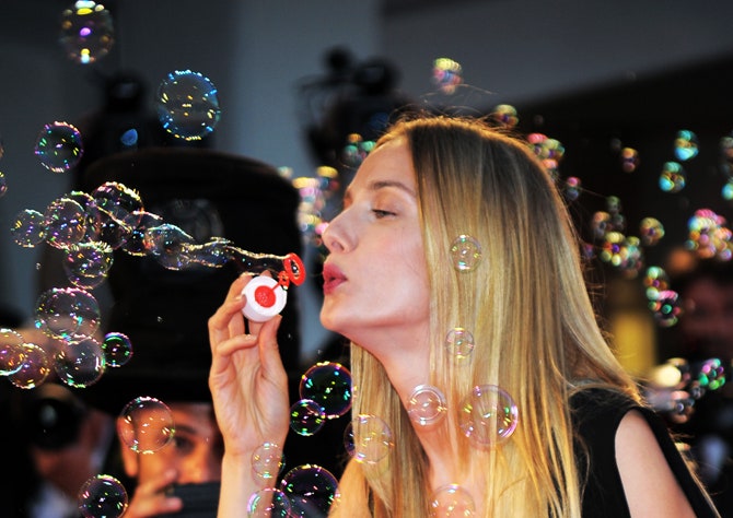 Ева Риккобоно выдувает мыльные пузыри в знак участия в благотворительной акции часового бренда JaegerLeCoultre